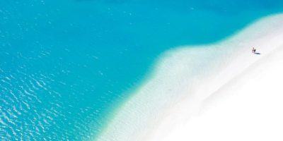 two people on the beach next to the sea